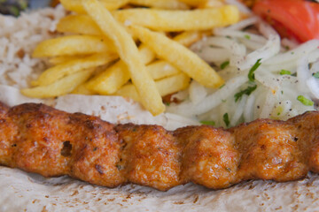 Delicious kebab served with fries and fresh salad