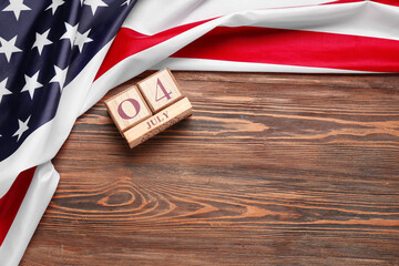 Cube calendar with date of Independence Day and national flag of USA on wooden background
