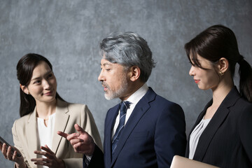 打ち合わせをするグレイヘアの社長のような男性と若い秘書のような女性