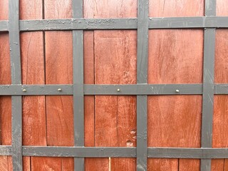 backdrop of a wooden gate with wrought iron in the shape of squares