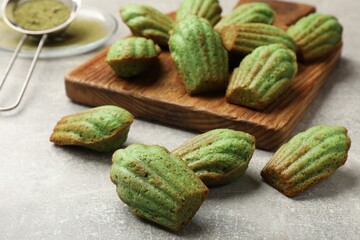 Tasty matcha madeleine cakes on light grey table, closeup