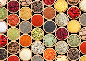 Set of different aromatic spices in bowls on black background, flat lay
