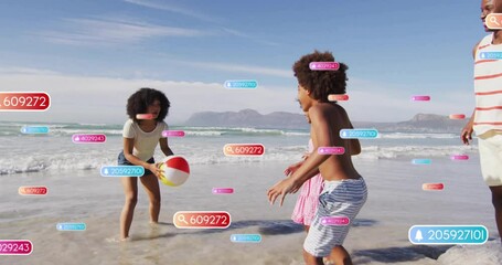 Family tossing beach ball at shoreline for recreation, activating AR numeric tags floating around - Powered by Adobe