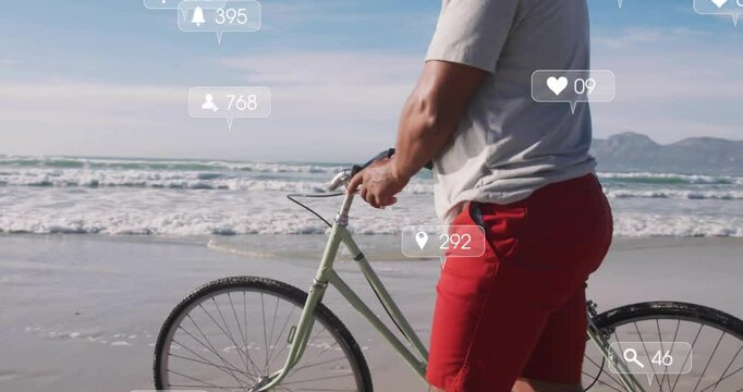 Man standing at shore activating media icons, pushing bicycle along sand showing marketing metrics