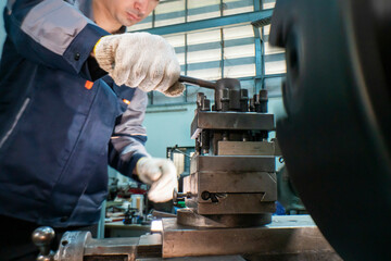 Close up view of a factory worker operating heavy industrial machinery with focus on precision. Gloved hands adjust the controls in a mechanical workshop, emphasizing safety, expertise, and metalwork.