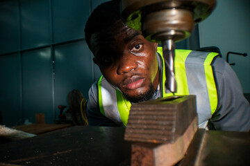 A focused engineer operating a heavy-duty drill machine, wearing a safety vest. The worker precision, determination, and industrial expertise, emphasizing workplace safety and machinery handling.
