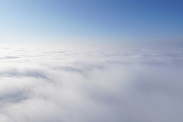 Vast sea of dense white clouds beneath a clear blue sky creating a serene and peaceful atmosphere