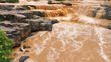 Floodwaters overflowing with force, seen from above, illustrating the growing impact of extreme...
