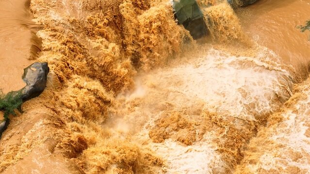 Drone captures muddy waters surging rapidly, highlighting the combined effects of heavy rainfall and deforestation in destabilizing soil and increasing flood hazards.
