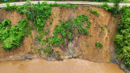Bird’s eye perspective captures earth displacement and fallen trees from a landslide, highlighting the increased vulnerability of deforested areas to heavy rain and flooding. Thailand.
