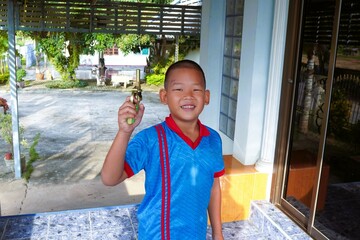 The boy smiled happily with a toy in his hand.