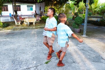 Two siblings in school uniforms getting ready to go to school.