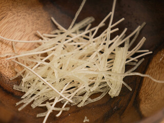 Vermicelli on wooden tray on white background