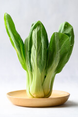 Organic Bok choy or Pak choi on wooden plate with white background, Fresh vegetable, Food ingredient