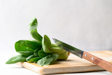 Organic Bok choy or Pak choi on cutting wooden board with kitchen knife, Fresh vegetable, Food ingredient