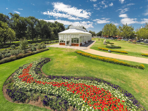 Looking down on flower beds and a conservatory in a park