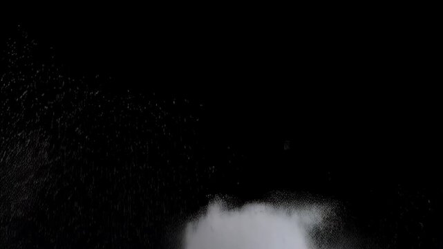 Abstract view of white powder explosion against black canvas background creates a mesmerizing visual effect, ideal for backgrounds.