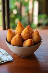 Coxinhas de frango em uma cumbuca, lanche tradicional brasileiro  sobre a superfície de uma mesa