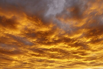 Obraz premium Dramatic golden sunset sky with fiery clouds
