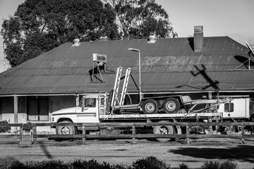A black and white image of a truck outside an old tavern in rural Western Australia.