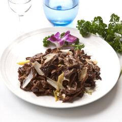 Braised lamb with green onions on a white porcelain plate