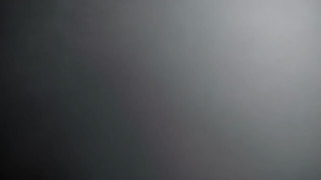 Neutral gray gradient backdrop with subtle texture for background design and presentation, seamless transition from dark to light