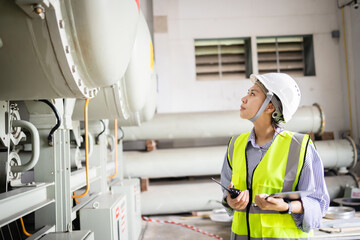 Electric engineer inspects gas insulated switchgear GIS in field ensuring electric grid operates...