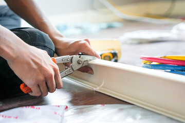 Worker Cutting Cable Trunking with Shears, Technician Service for Repair and Maintenance of Air Conditioners, Hands Using Pliers to Trim Electrical Conduit