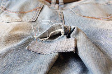 Sewing needles and thread, embroidered on the denim pants. Repair of defects