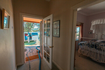 Carpet cleaning professional outside home with hoses running to van