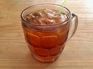 Iced tea in a large mug on the table. The freshness of sweet iced tea.