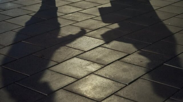 Exchange of briefcase and envelope in secret deal in street by two people. Shadows of man and woman making dirty business deal or criminal activity. Shady suspicious payment or bribe by agent or spy