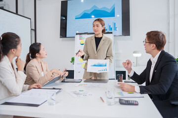 Group of Asian business people presenting their work on a board or on a tablet.