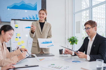 Group of Asian business people presenting their work on a board or on a tablet.
