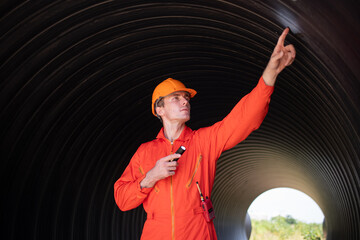 Construction surveyor or engineer working in pipe construction site for inspection detail of...