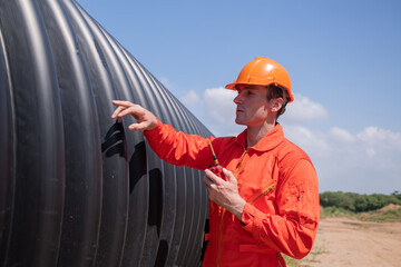 Construction surveyor or engineer working in pipe construction site for inspection detail of...