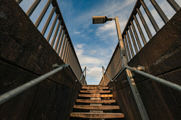 Concrete stairs leading to pedestrian walkway on Stockton Brigde with soft blue sky