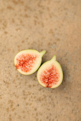 Flat lay image of fig fruit cut in half on textured background