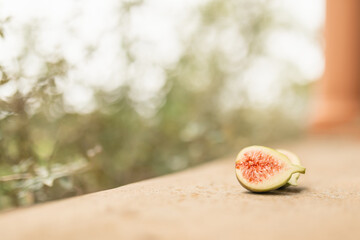 Fresh fig fruit cut in half in natural garden setting with copy space