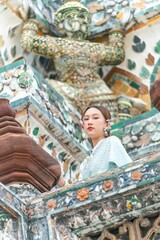 Obraz premium Young Woman in Traditional Thai Dress at Wat Arun, Temple of the Dawn, Bangkok, Thailand