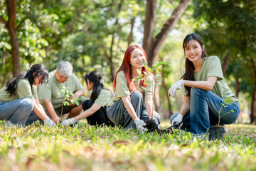 Fototapeta premium Asian Volunteers Team Planting Tree for Environmental Conservation, Eco-Friendly Group Activity