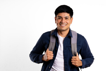 Young latin man, on white background, smiles looking at the camera carrying backpack
