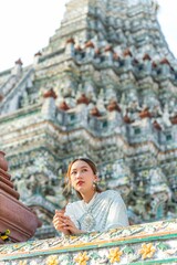 Obraz premium Young Woman in Traditional Thai Costume at Wat Arun, Temple of Dawn, Bangkok, Thailand