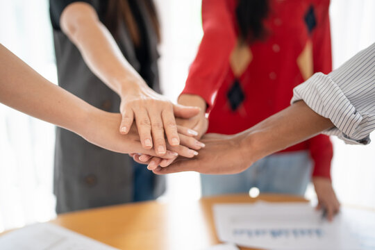 Team building group of people Asian business hands stack unity and support Team fold their hands on each other
