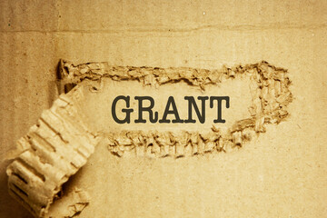 The words about grant funding are written on torn corrugated cardboard. 