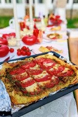 Homemade pizza with pesto and tomatoes, baked in a village oven.