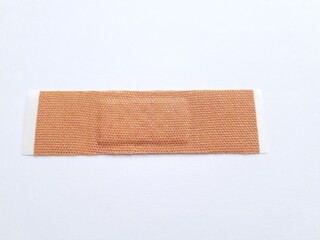 Unbranded wound plaster or band aid isolated on white background.