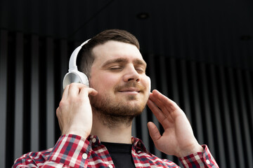 Attractive young guy listens to music in headphones