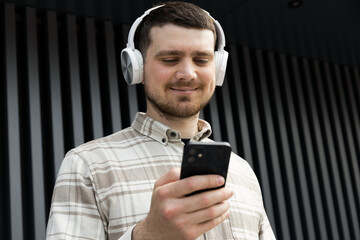 Attractive young guy listens to music in headphones