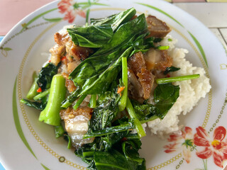 fried crispy pork and basil leaf with garlic and rice on plate